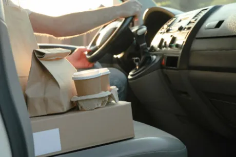 A takeaway order sitting on the car passenger seat
